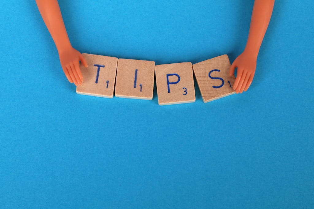 Scrabble tiles spelling 'TIPS' on a blue background, ideal for creative concepts.